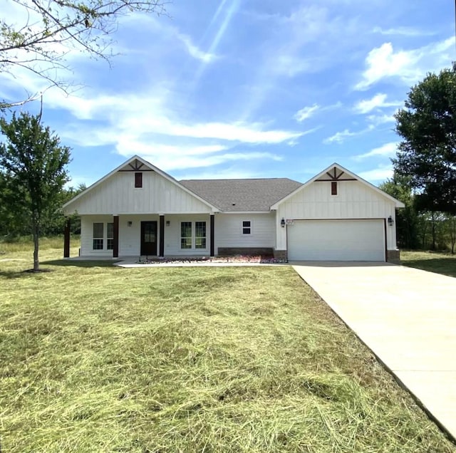 view of front facade featuring a garage, a front yard, concrete driveway, and roof with shingles