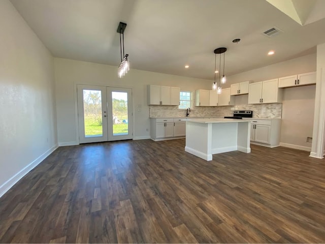 kitchen featuring white cabinets, decorative light fixtures, and plenty of natural light