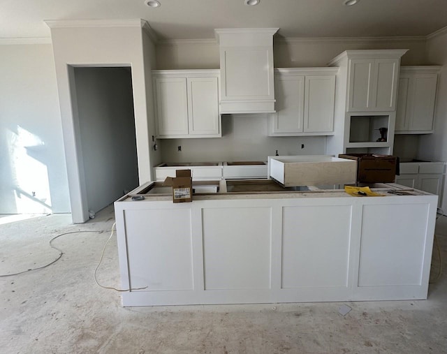 kitchen featuring white cabinetry, a center island, and ornamental molding