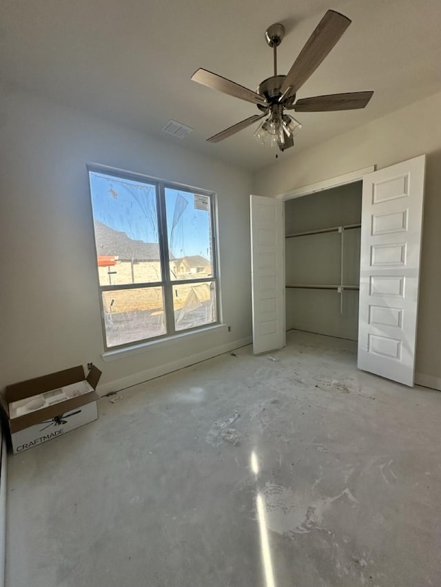 unfurnished bedroom featuring ceiling fan, a closet, and concrete flooring