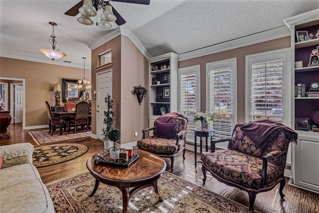 sitting room with hardwood / wood-style floors, ornamental molding, and a textured ceiling