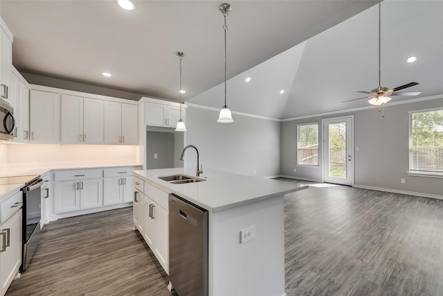 kitchen with lofted ceiling, white cabinets, sink, an island with sink, and stainless steel appliances