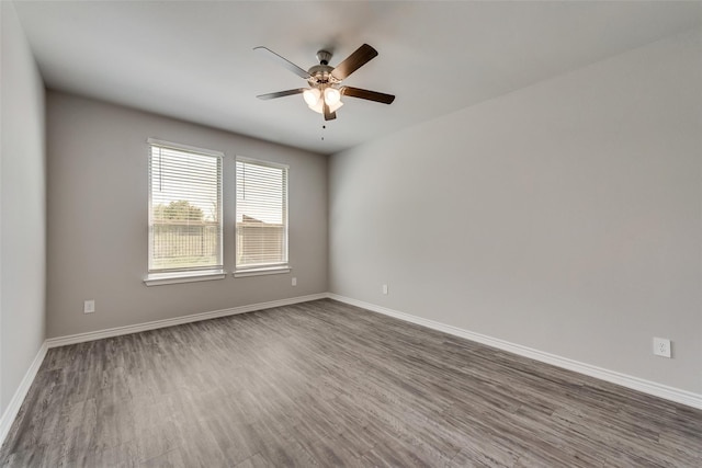 empty room with ceiling fan and dark wood-type flooring