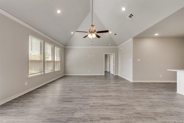 unfurnished living room featuring ceiling fan, high vaulted ceiling, ornamental molding, and light wood-type flooring