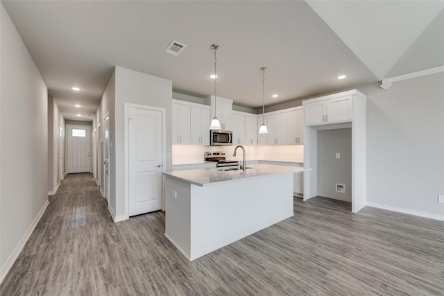 kitchen with sink, light hardwood / wood-style floors, a kitchen island with sink, white cabinets, and appliances with stainless steel finishes