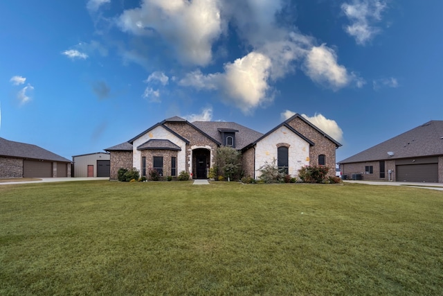 french country style house with a garage and a front yard