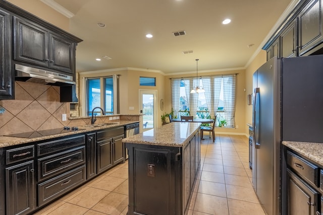 kitchen featuring appliances with stainless steel finishes, light tile patterned floors, a kitchen island, and crown molding