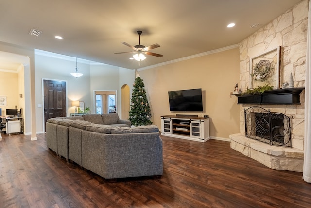 living room with a fireplace, dark hardwood / wood-style flooring, ceiling fan, and crown molding