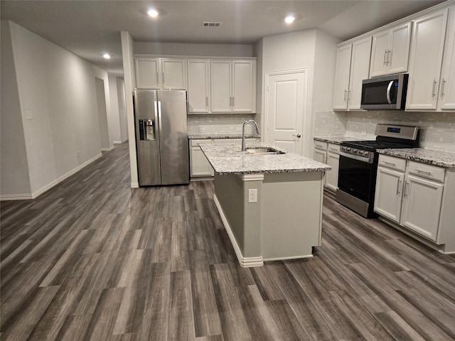 kitchen featuring sink, white cabinetry, light stone counters, a center island with sink, and appliances with stainless steel finishes