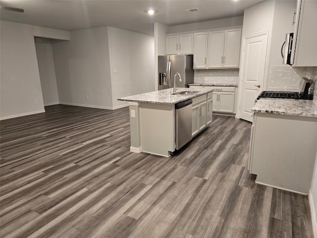 kitchen with appliances with stainless steel finishes, dark wood-type flooring, a center island with sink, and white cabinets