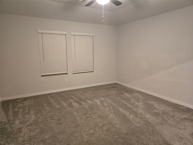 empty room with ceiling fan and dark carpet