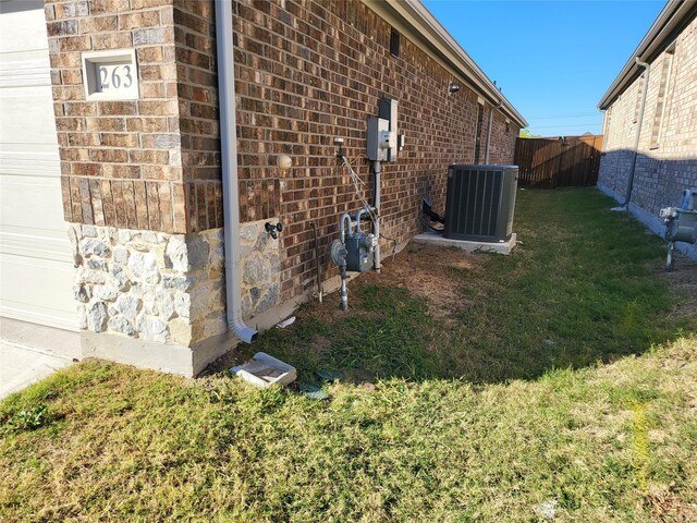 view of home's exterior with central AC and a lawn