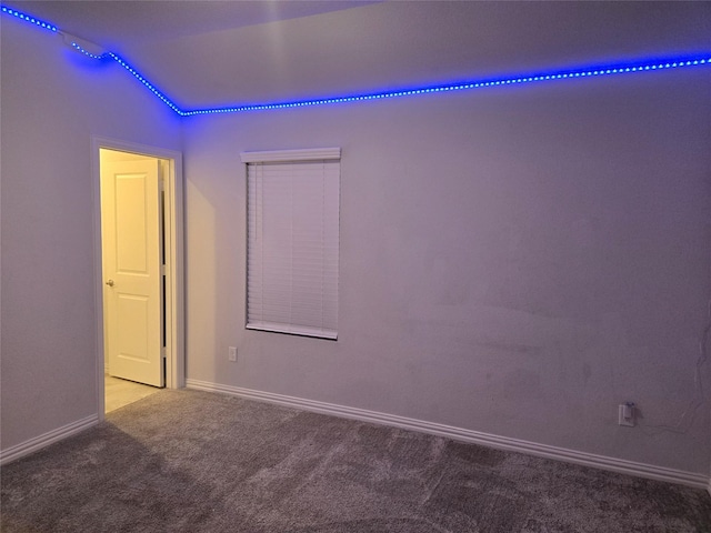 carpeted spare room with vaulted ceiling