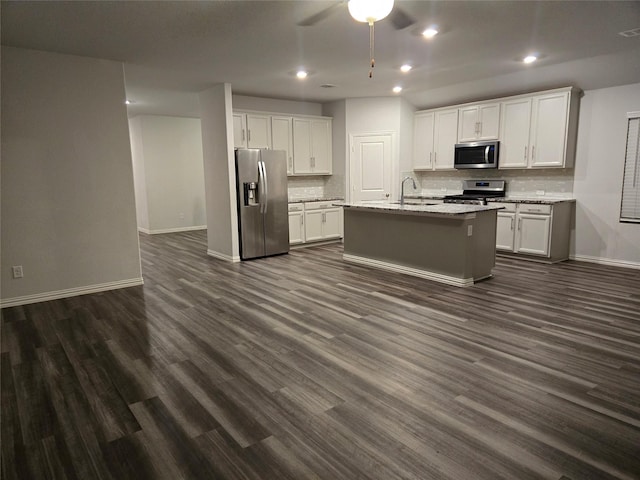 kitchen featuring stainless steel appliances, white cabinetry, a kitchen island with sink, and sink