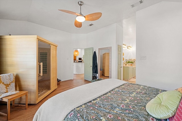 bedroom featuring light hardwood / wood-style floors, vaulted ceiling, and ceiling fan