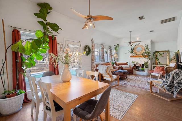 dining space featuring ceiling fan, vaulted ceiling, and hardwood / wood-style flooring