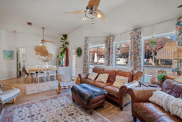 living room featuring ceiling fan, light wood-type flooring, and lofted ceiling