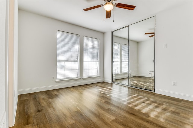 unfurnished bedroom with hardwood / wood-style floors, ceiling fan, and a closet