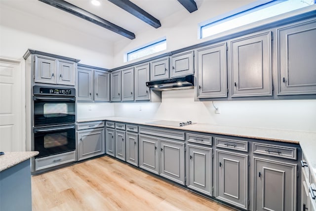 kitchen featuring beam ceiling, gray cabinetry, light hardwood / wood-style flooring, black double oven, and electric stovetop