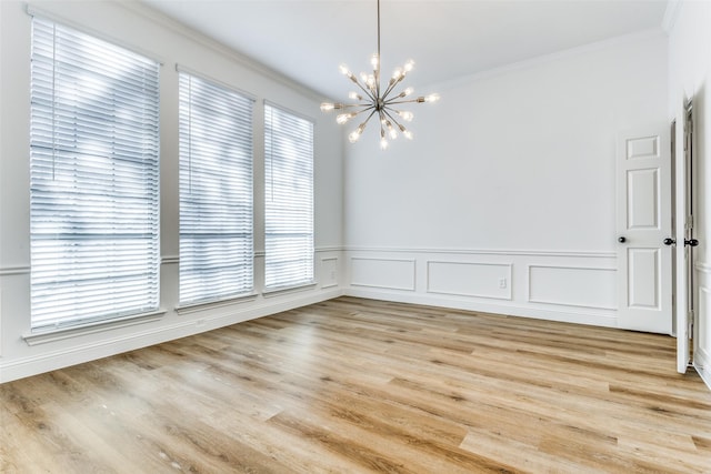 unfurnished room with crown molding, plenty of natural light, and light hardwood / wood-style flooring