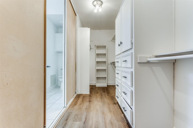 walk in closet with light wood-type flooring