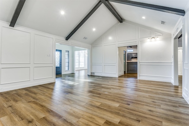 unfurnished living room with hardwood / wood-style floors and lofted ceiling with beams