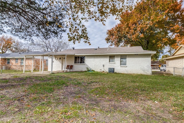 rear view of property featuring central air condition unit and a yard