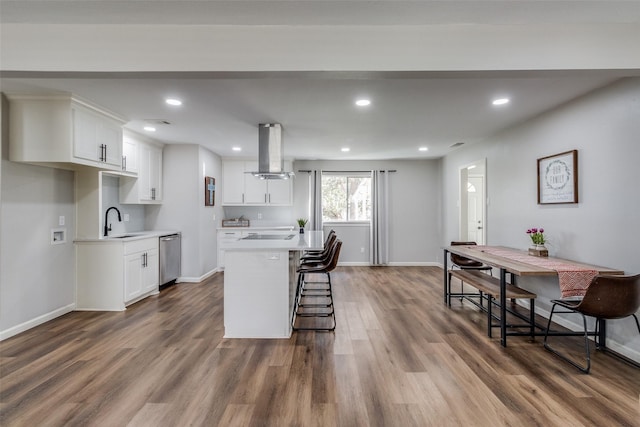 kitchen featuring island exhaust hood, a center island, white cabinets, and hardwood / wood-style flooring