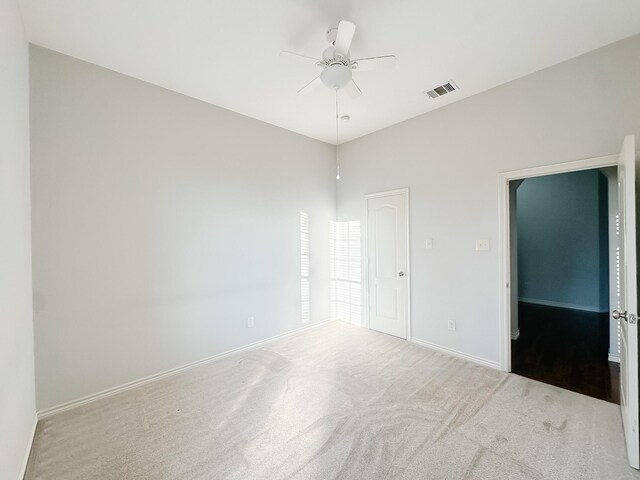 carpeted spare room featuring ceiling fan