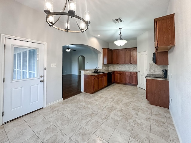 kitchen featuring pendant lighting, ceiling fan with notable chandelier, sink, tasteful backsplash, and light tile patterned flooring