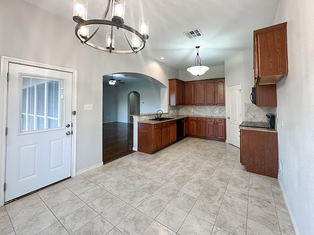 kitchen with an inviting chandelier, visible vents, decorative backsplash, arched walkways, and a sink