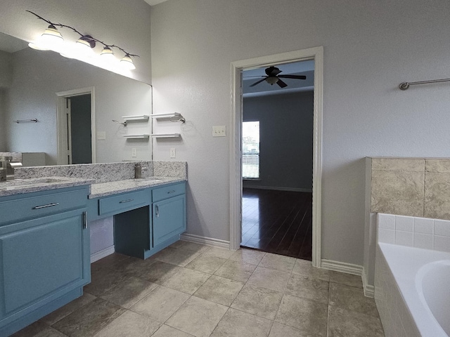 bathroom with vanity, a garden tub, baseboards, and a ceiling fan