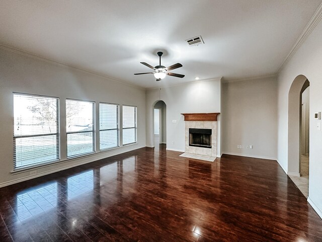 unfurnished living room with dark hardwood / wood-style flooring, ceiling fan, a fireplace, and crown molding