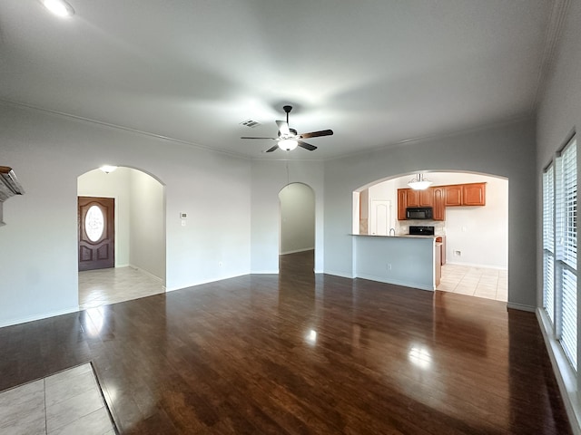 unfurnished living room with ceiling fan, a healthy amount of sunlight, ornamental molding, and light hardwood / wood-style flooring