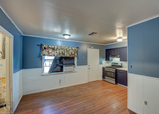 kitchen with crown molding, wood-type flooring, stainless steel range with gas stovetop, and cooling unit