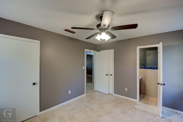 unfurnished bedroom featuring ceiling fan, ensuite bathroom, and light tile patterned floors