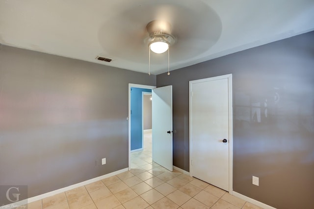 unfurnished bedroom featuring light tile patterned floors, ceiling fan, and a closet