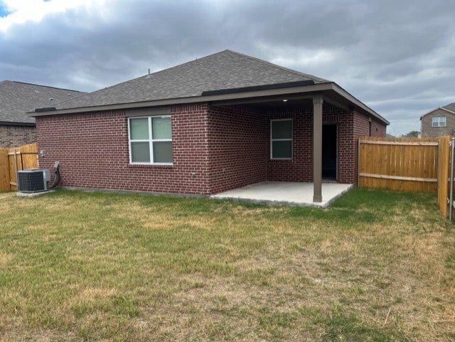 rear view of house featuring central AC, a patio, and a lawn