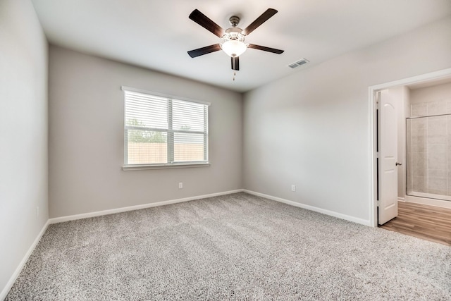 spare room with ceiling fan and light carpet