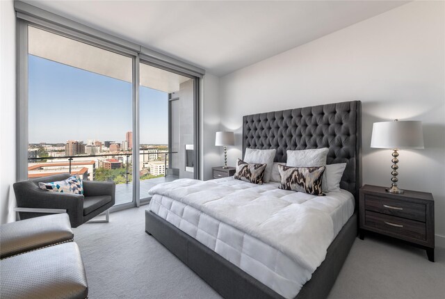 carpeted bedroom with access to exterior and a wall of windows
