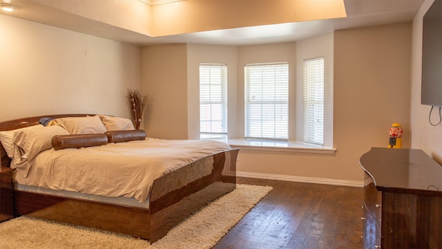 bedroom with baseboards and wood finished floors