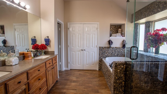 bathroom featuring vanity, wood-type flooring, high vaulted ceiling, and independent shower and bath