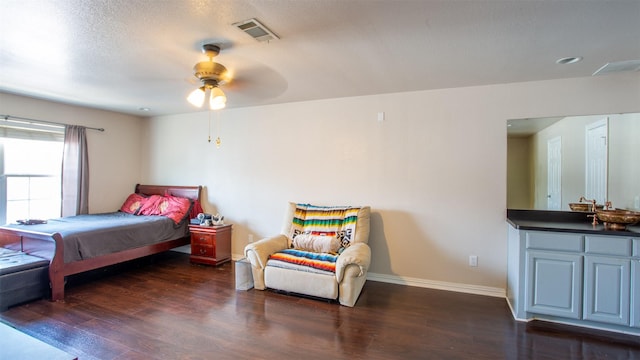 bedroom with ceiling fan, dark hardwood / wood-style floors, and a textured ceiling