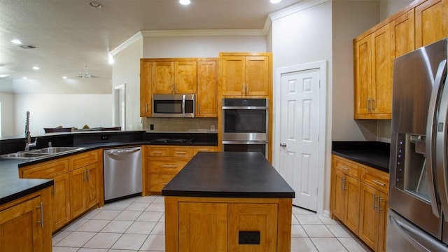 kitchen with dark countertops, light tile patterned floors, a sink, and stainless steel appliances