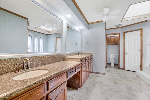 bathroom featuring a ceiling fan, crown molding, a sink, and double vanity