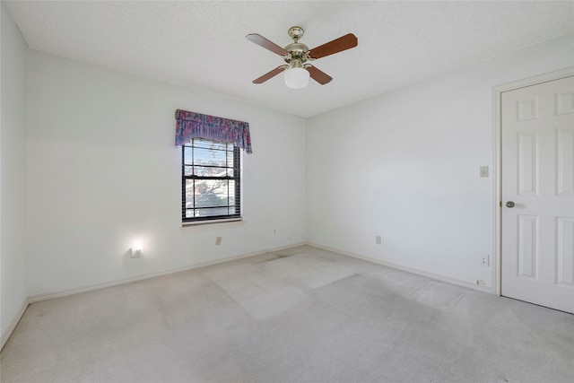 carpeted spare room with ceiling fan and a textured ceiling