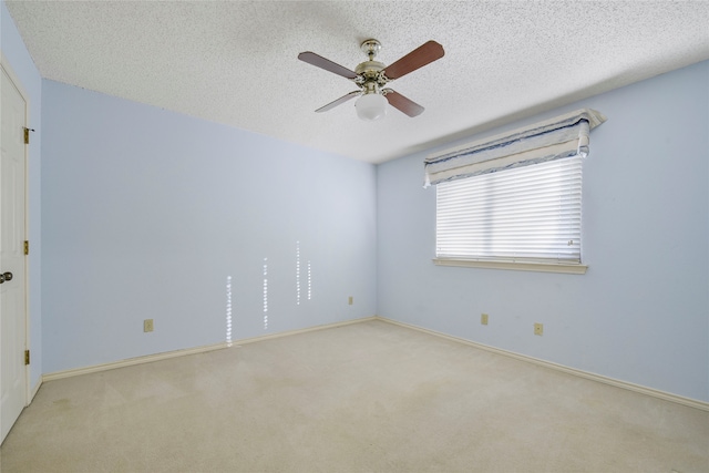 unfurnished room with ceiling fan, light colored carpet, and a textured ceiling