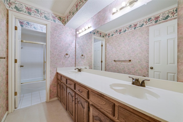 full bath with double vanity, enclosed tub / shower combo, a sink, and wallpapered walls