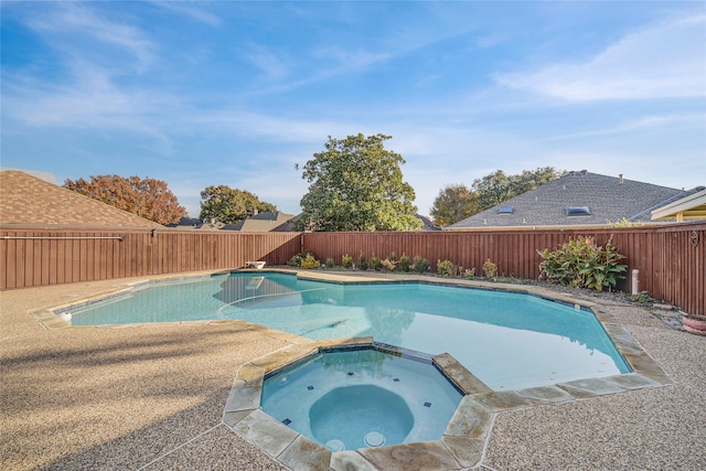 view of pool featuring a fenced backyard and a pool with connected hot tub