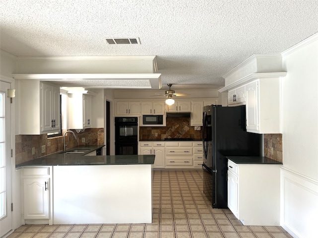 kitchen featuring dark countertops, visible vents, a sink, a peninsula, and black appliances